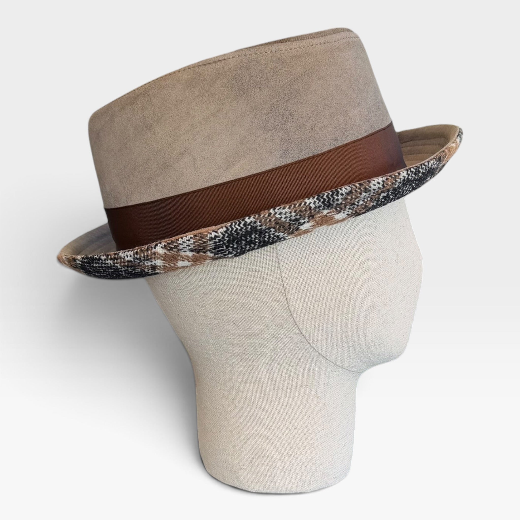 Cappello pork pie in pelle beige, vista laterale su manichino, con fascia marrone e bordo tartan