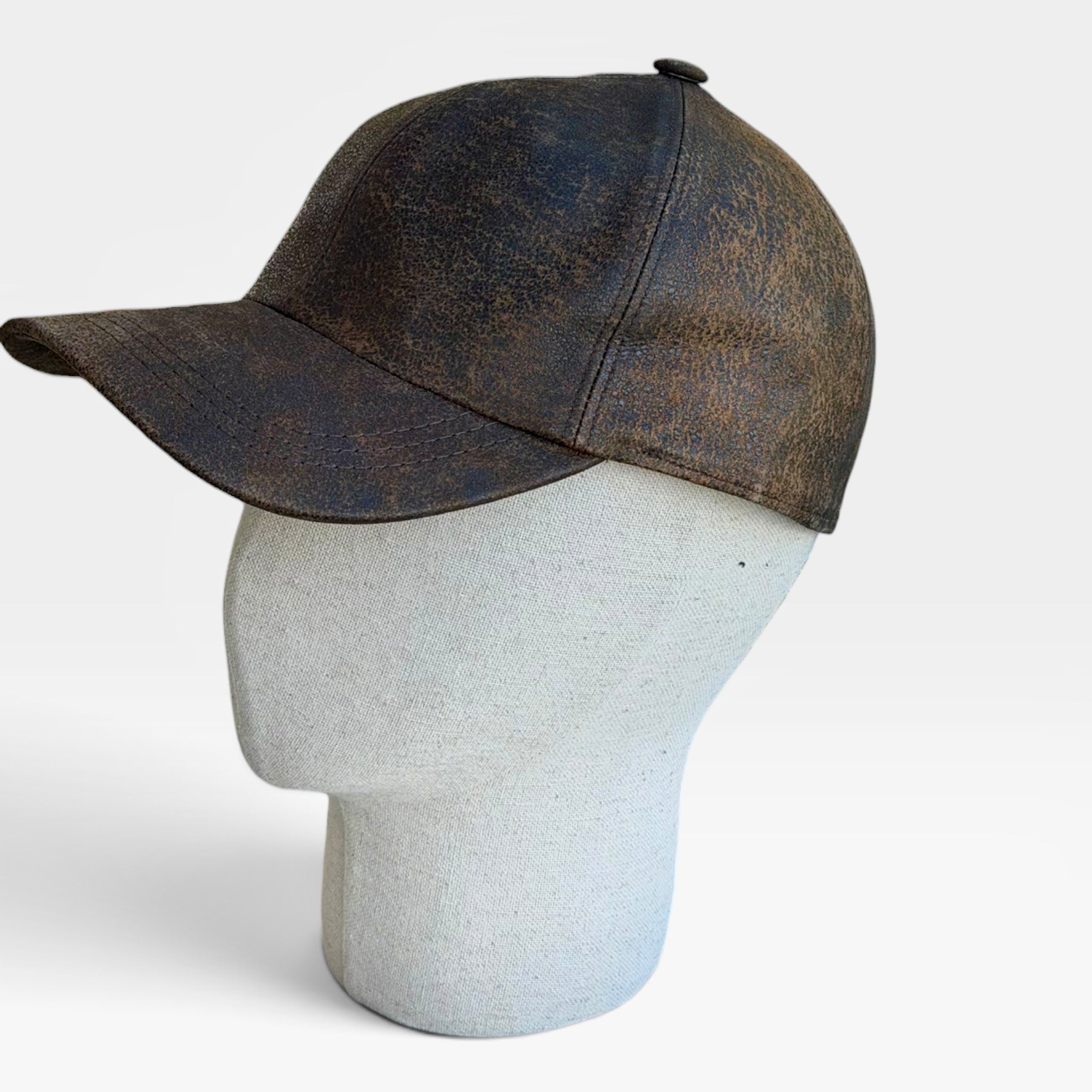 Cappellino baseball in pelle marrone visto di lato su manichino
