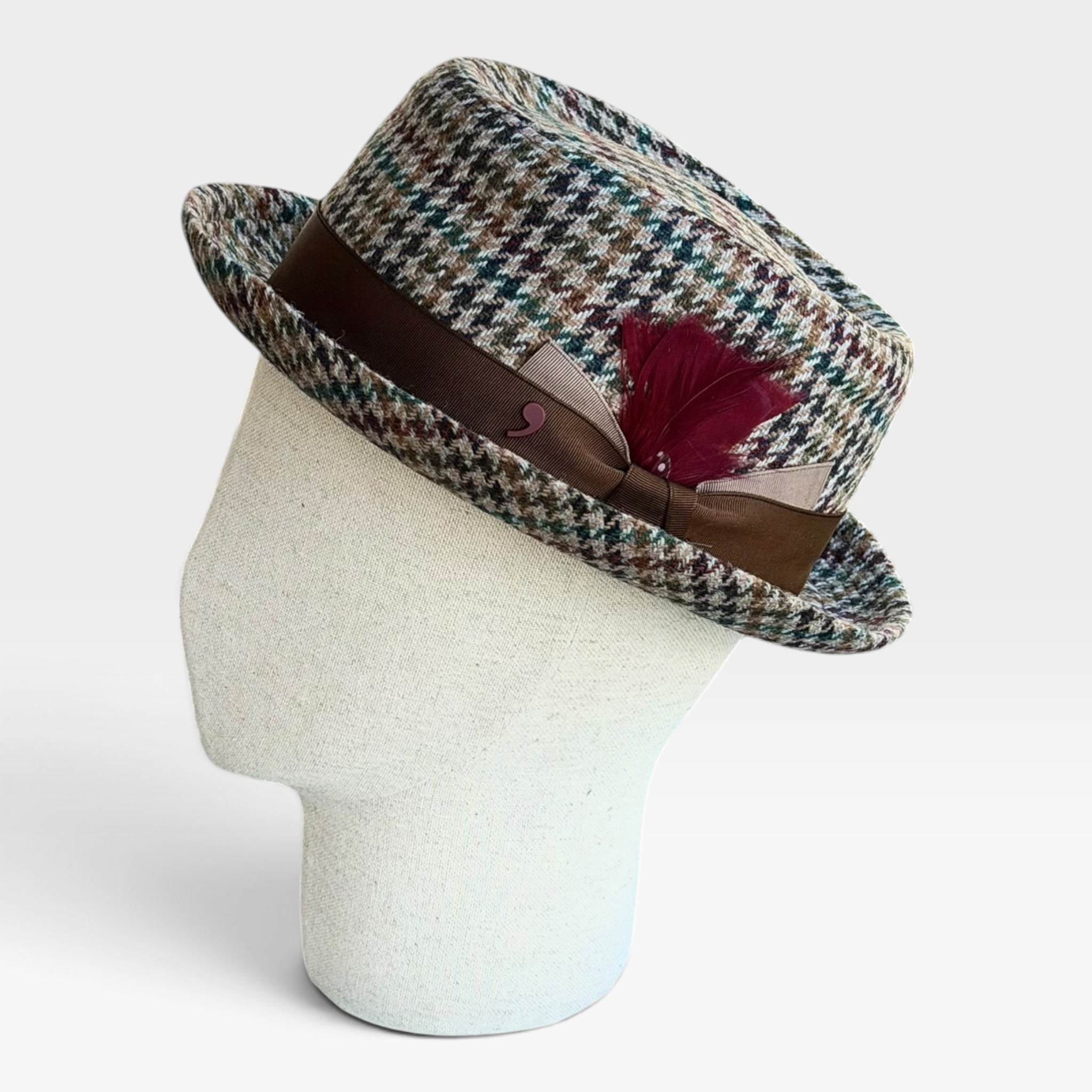 Cappello Pork Pie invernale in lana motivo Glen Check con piuma e fascia marrone su manichino