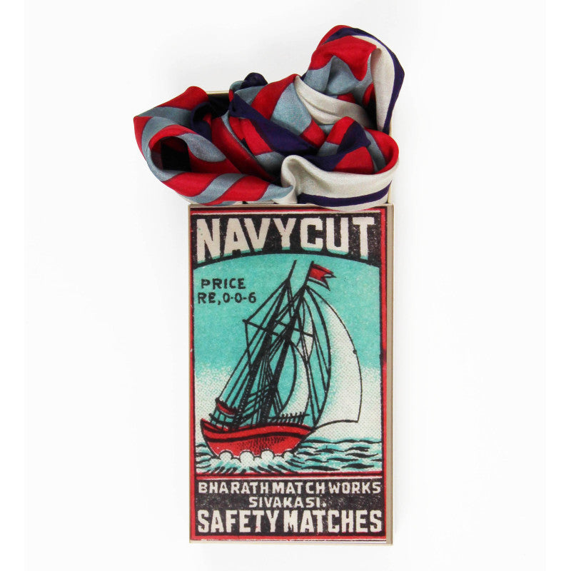 Foulard piegato accanto a confezione ispirata a scatola di fiammiferi vintage navy cut