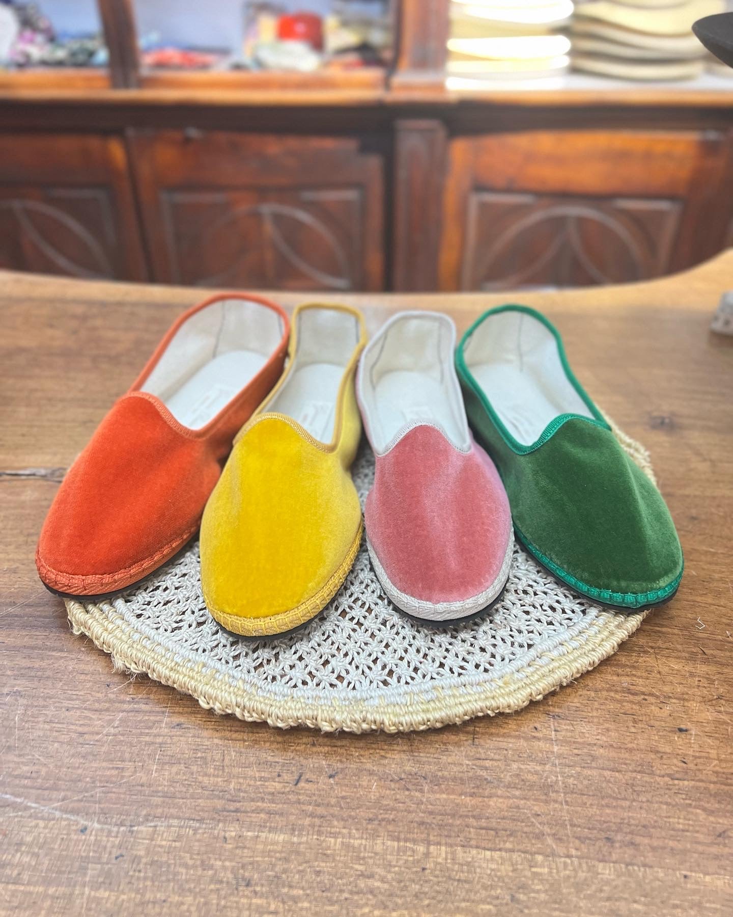 Scarpe friulane disposte a raggiera nei colori arancione, giallo, rosa e verde smeraldo